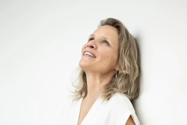 Marianne Ziegler, Trauma-sensible Coachin, lachend vor weissem Hintergrund